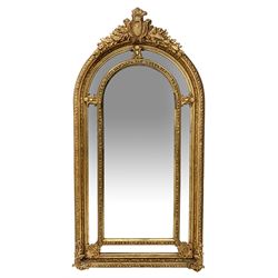 Gilt Rococo style mirror, arched top with central cartouche and oak leaf moulded pediment, floral and fruit moulded surround with segmented glass panels, bevelled central pane, c-scroll shell and acanthus leaf brackets
