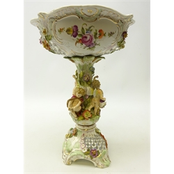  Late 19th century German Potschappel centrepiece, the base encrusted with fruit and flowers with pierced panels, the floral encrusted stem with applied with four cherubs supporting the pierced and hand painted bowl, H40cm   