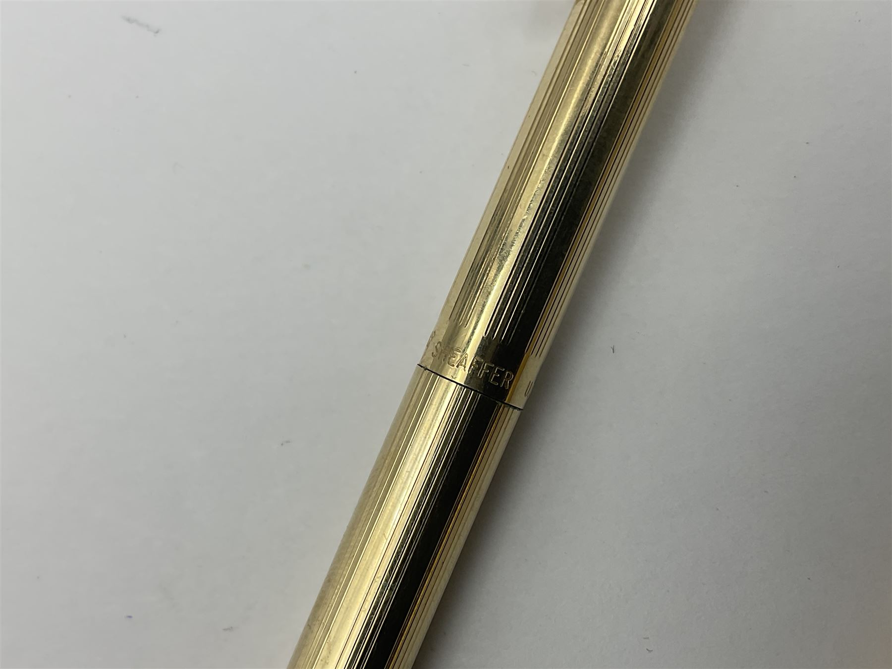 Sheaffer Triumph Imperial fountain pen, the gold plated barrel with fluted stripe design and gold nib stamped 14K 585, together with a Sheaffer Targa slimline fountain pen with gold plated barrel similarly decorated with gold nib stamped 14K 585, ballpoint pen and propelling pencil, each with a fluted gold plated barrel, largest L13.5cm (4)