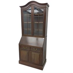 Late 19th century mahogany bureau bookcase, the shaped and moulded pediment over two astragal glazed doors, fall front enclosing fitted interior, two drawers and double cupboard below, on skirted base