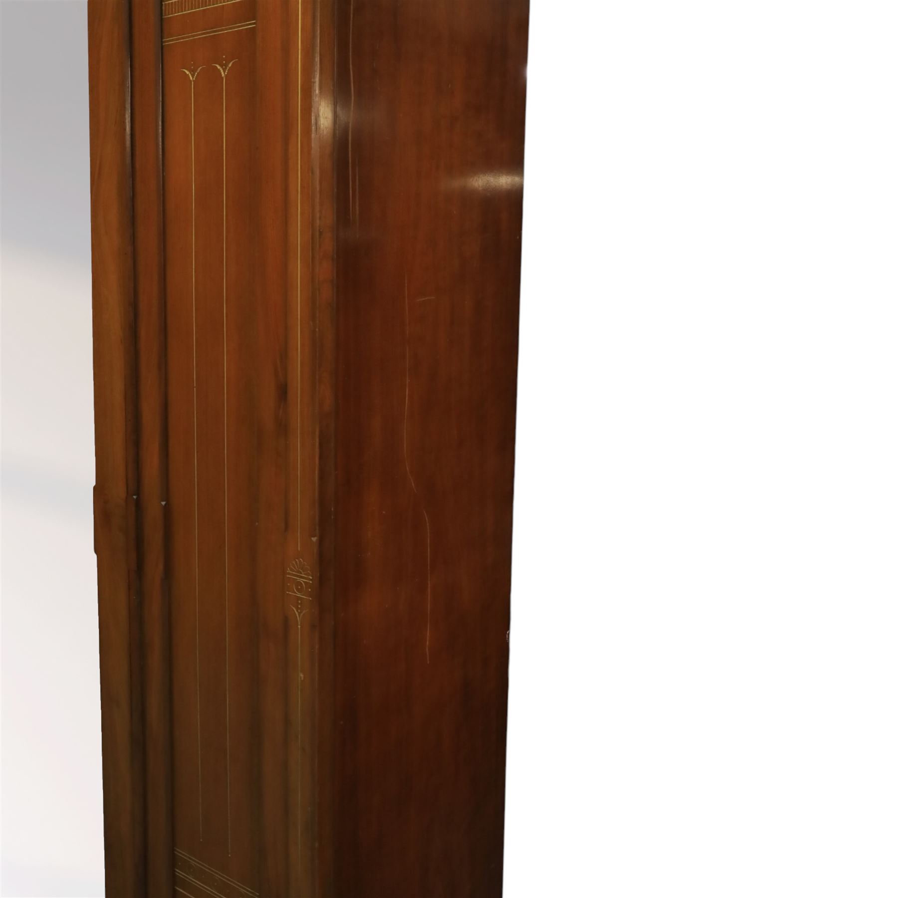 Aesthetic Movement walnut parcel gilt wardrobe, the crenellated top, above central mirrored door opening to reveal hanging space, four opened and two closed draws