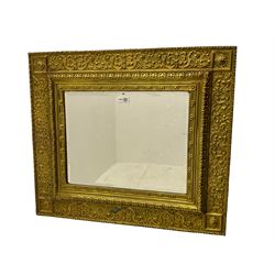 20th century rectangular mirror, in brass repousse frame decorated with scrolls and foliate, bevelled mirror plate