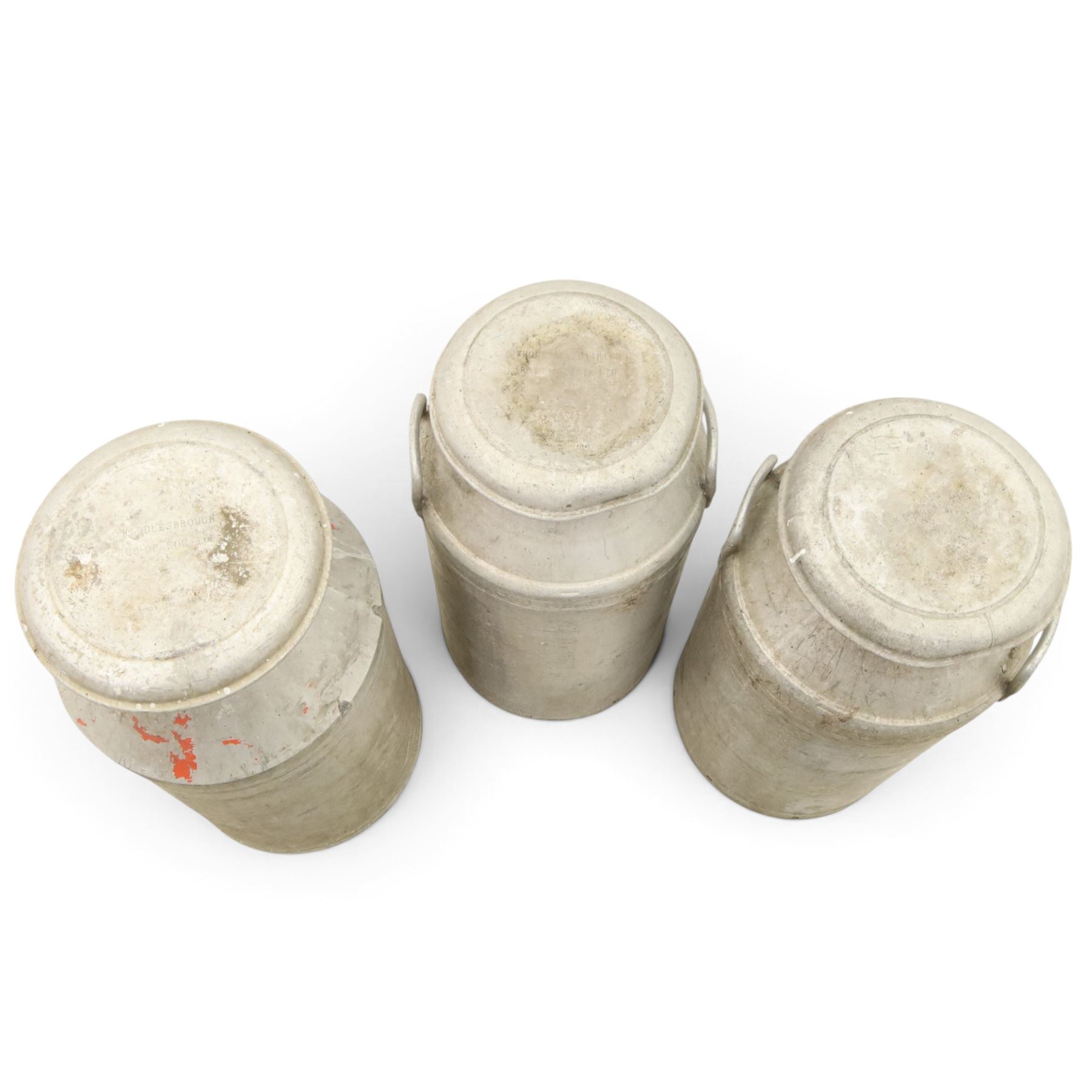 20th century aluminium set of three milk churns, with handles, baring the stamps of 'Middlesborough Co-op', 'Holme Moor', 'Wholesale Dairies' 