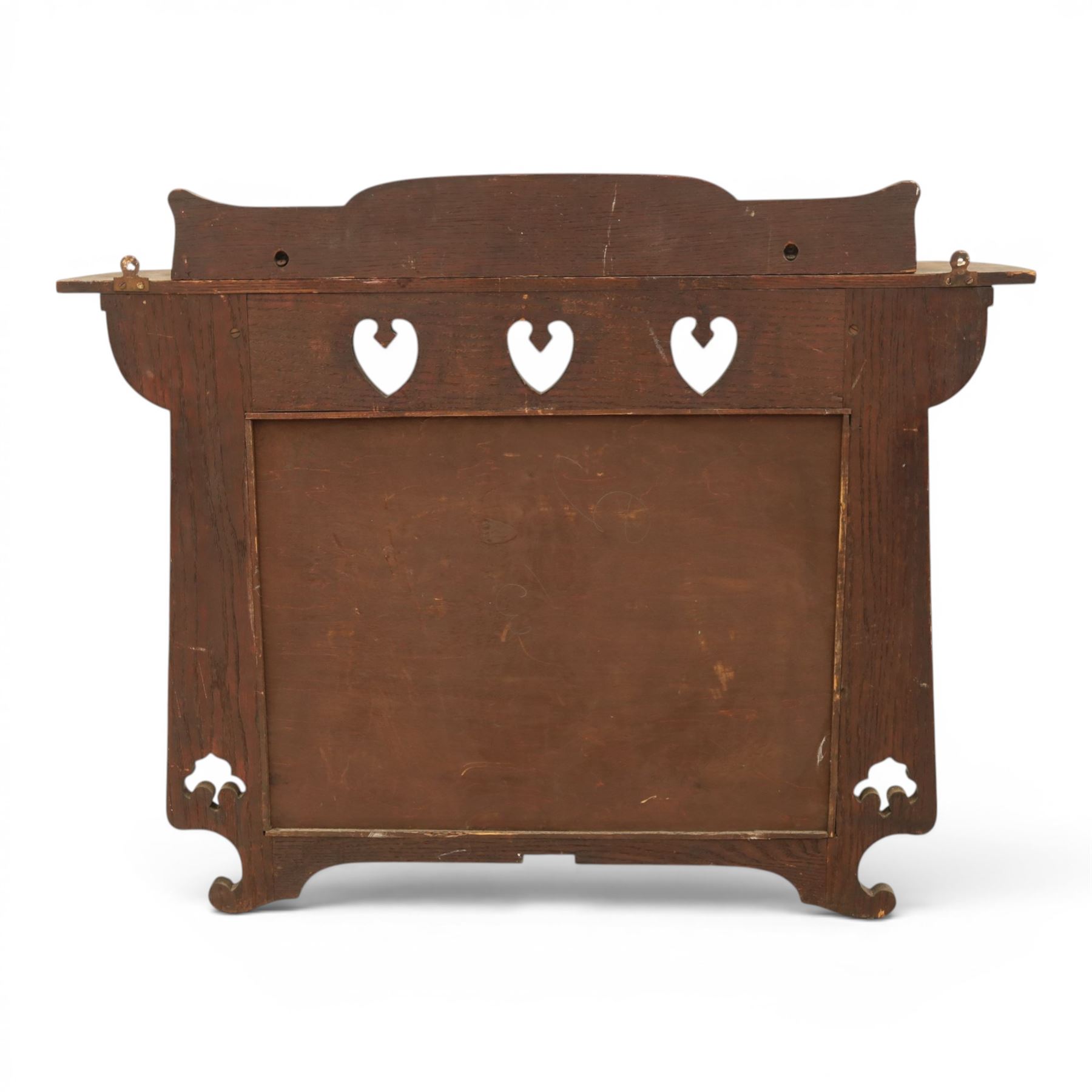 Arts and Crafts oak wall mirror, rectangular mirror plate within shaped frame, raised shelf with shaped back and pierced heart detail, bracket supports and shaped lower rail