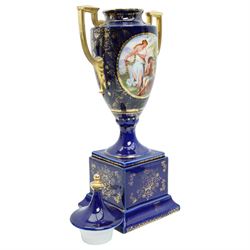 Pair of Vienna style blue porcelain two handled vases and covers painted with classical scenes on a dark blue and gilt ground and square socles, blue beehive mark H35cm