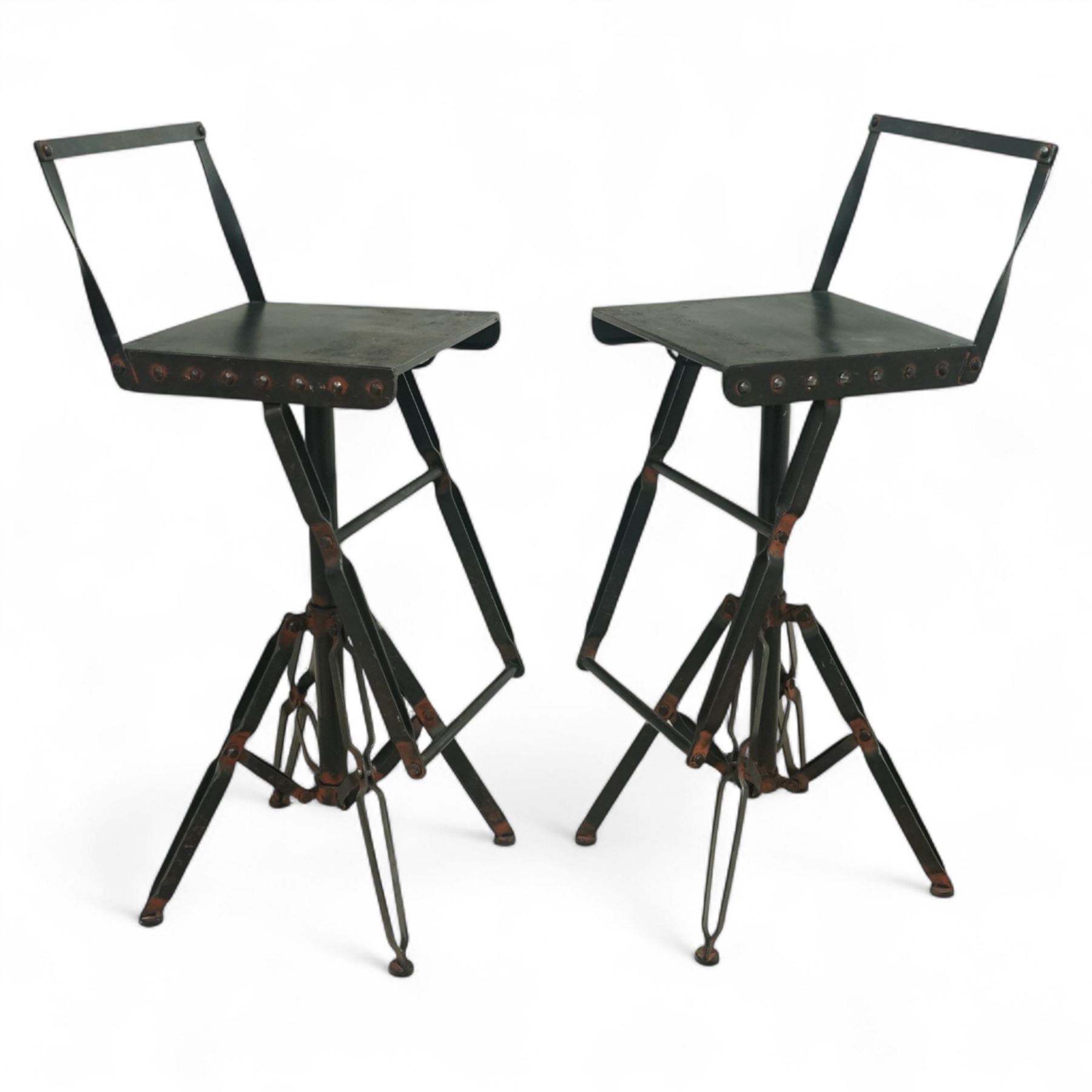Pair of 20th century brutalist industrial metal swivel bar stools, sheet seats with strap backrests with bolted design to the sides, raised on quadripod bases with angular strut supports, the seats height-adjustable and swivelling