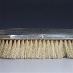 Five silver mounted dressing table items, including 1920s mirror and hairbrush set, with engraved initial to reverse, pair of clothes brushes with engraved initials and engine turned decoration and an oval clothes brush, all hallmarked 