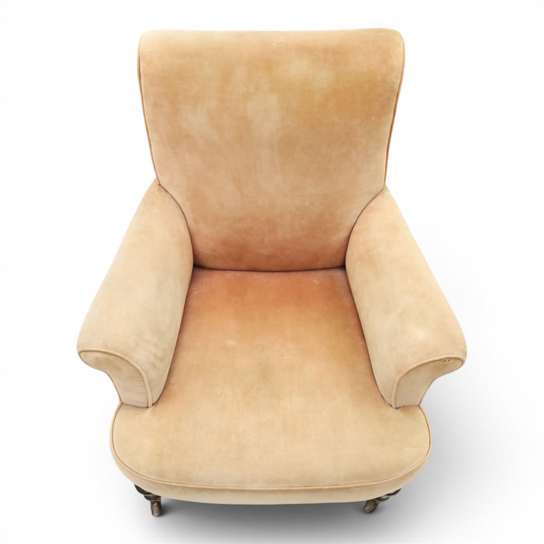 Victorian mahogany framed armchair of traditional shape, the high sprung rolled back over out-swept arms, deep sprung seat over turned feet with ceramic castors, upholstered in pale salmon pink fabric