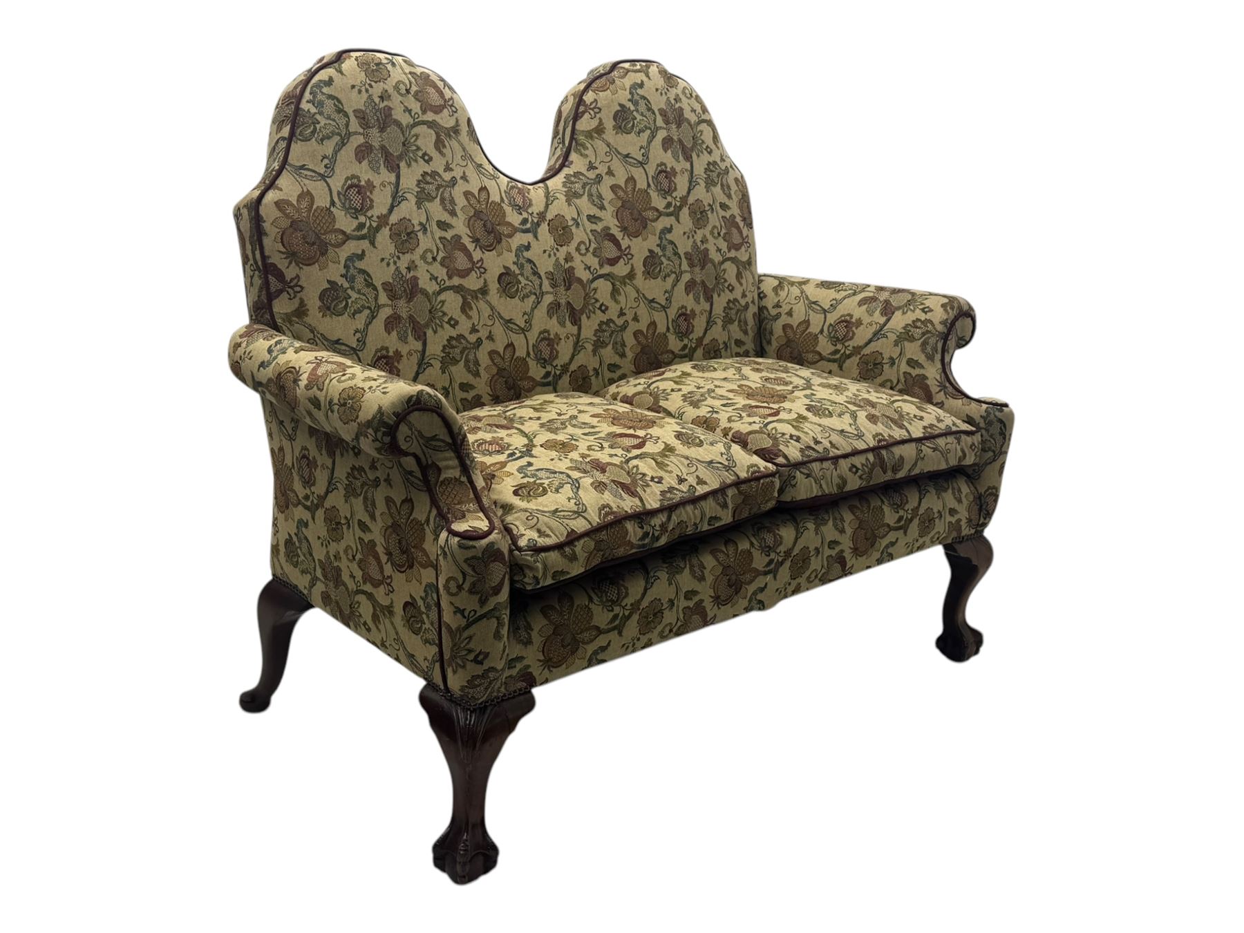 Mid-20th century William and Mary design two-seat sofa, upholstered in floral patterned fabric with contrasting piping, featuring camel-shaped back and scroll arms, on cabriole supports