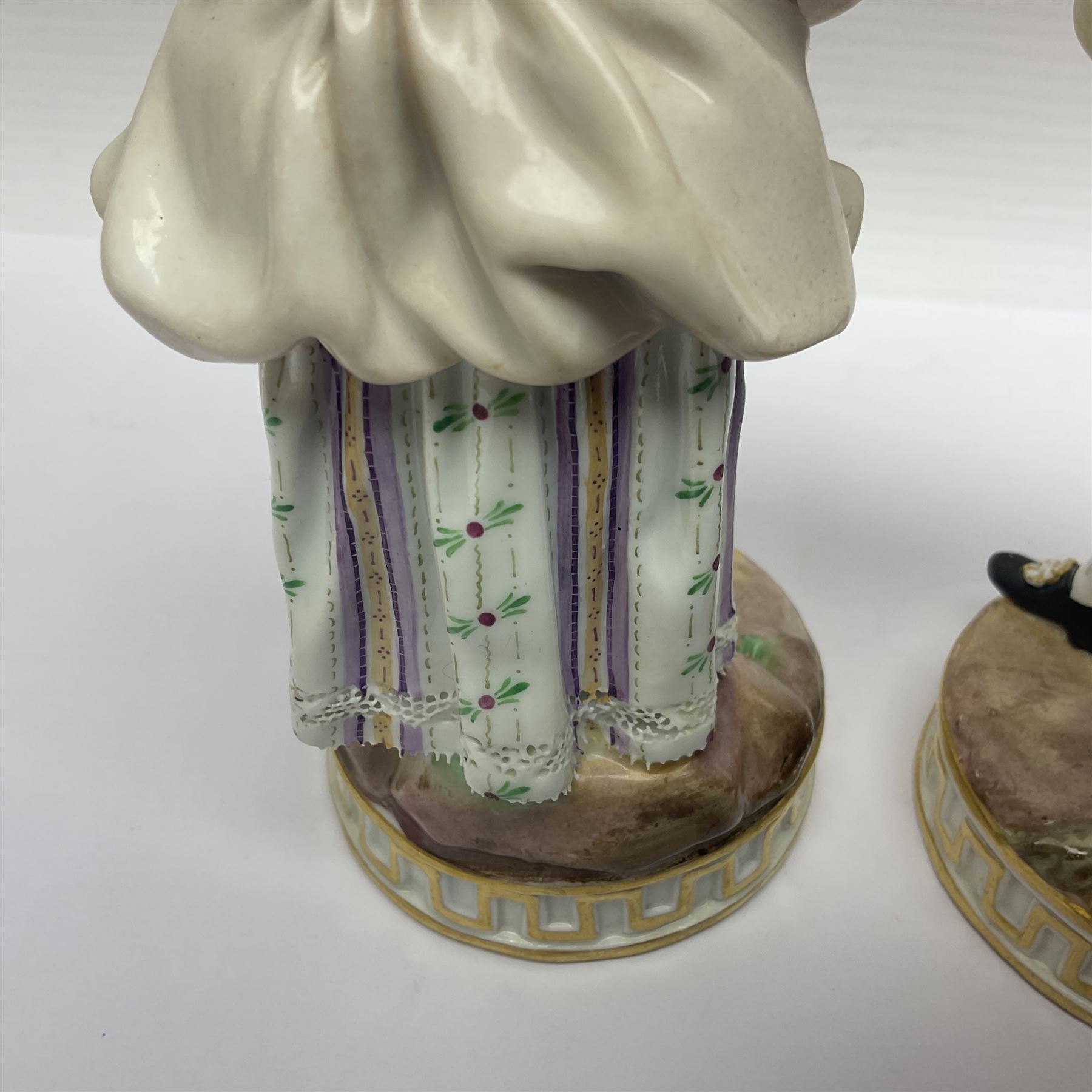 Pair of late 19th/early 20th Century Meissen figures, modelled as flower sellers, after the original by Michel Victor Acier, she holding basket of flowers, he holding flowers in his hat, each with underglaze cross swords mark beneath, tallest H16.5cm
