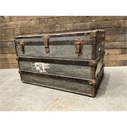 Early 20th century wood and metal bound zinc travelling trunk, hinged top with three clasps, decorated with period luggage labels