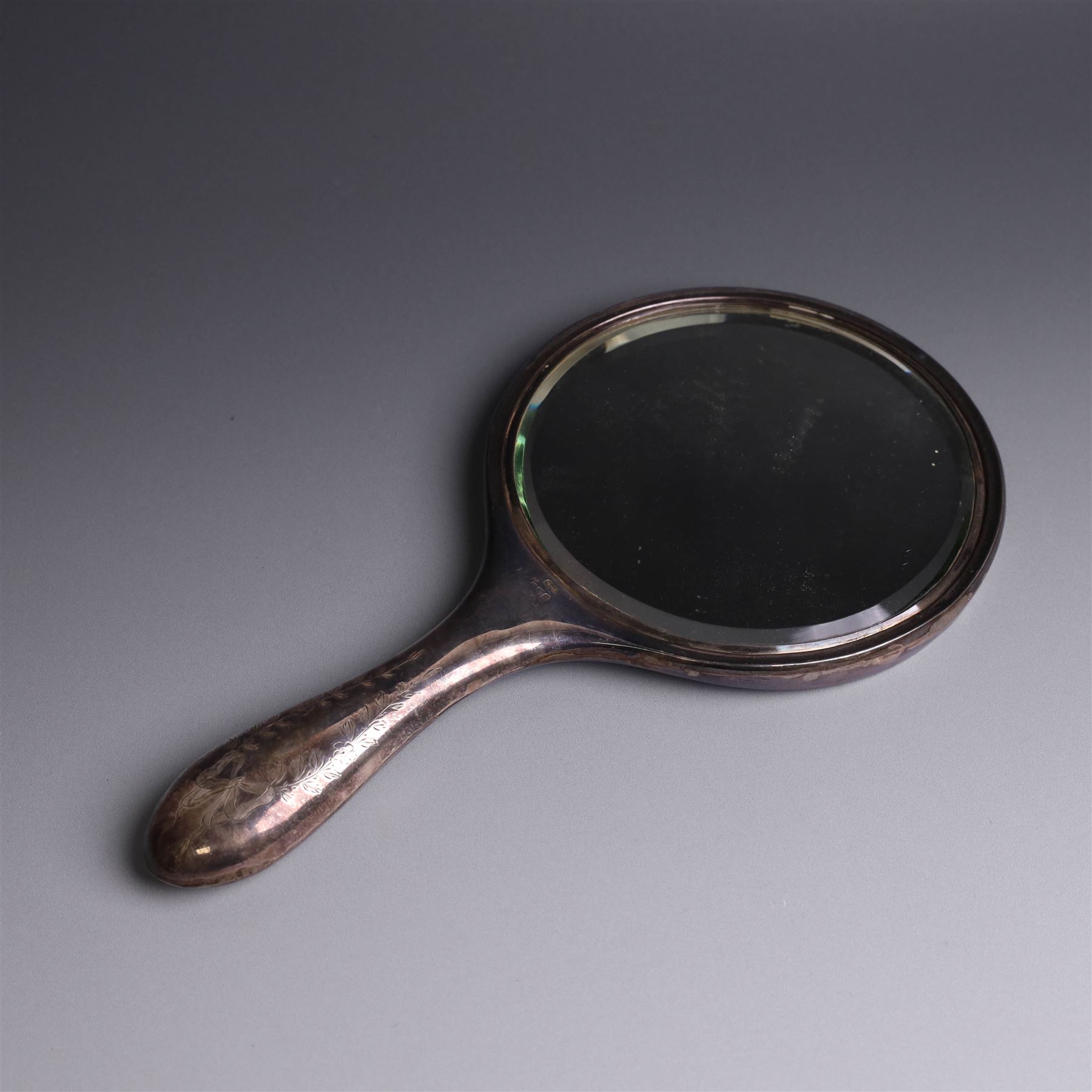 Early 20th Century silver mounted dressing table set, comprising hand mirror, shoe horn and a button hook, each with engraved floral decoration, together with a silver mounted hairbrush and clothes brush, all hallmarked
