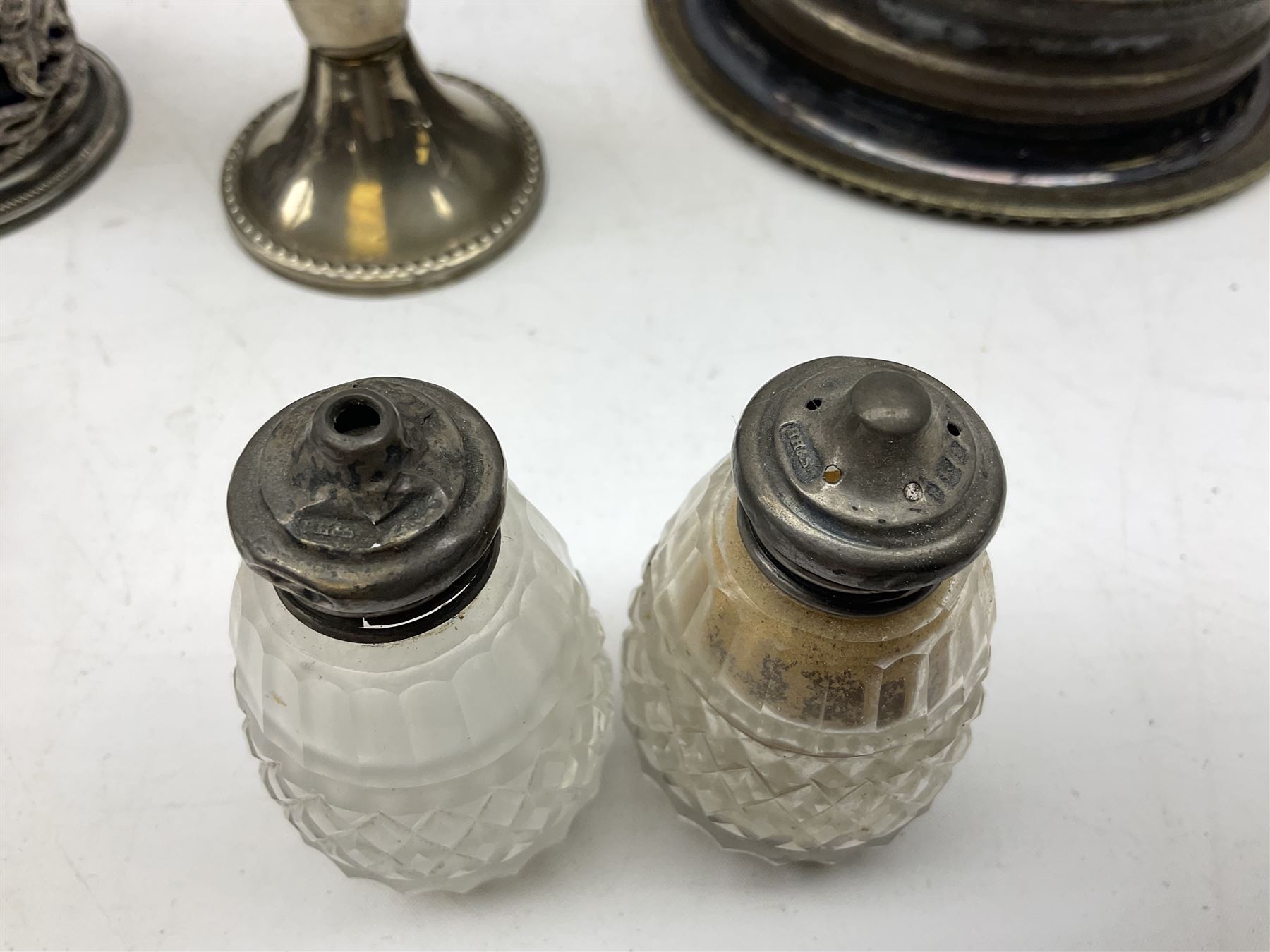 Four 19th century silver plated wine bottle coasters, together with hallmarked silver collared and lidded glass cruet trio and ornate silver cruet holder missing liner, with handle, and other silver plate etc