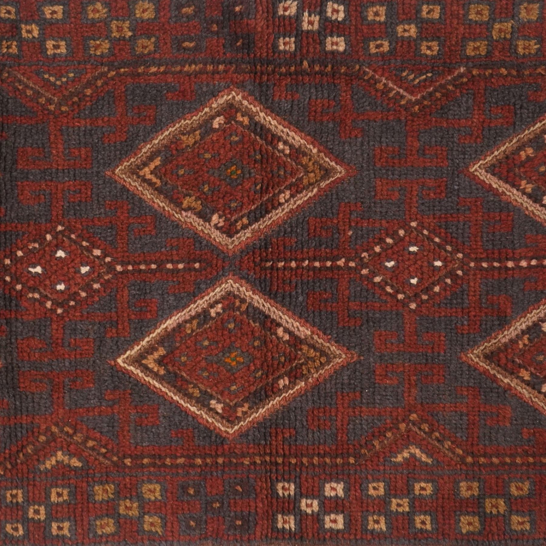 Afghan Meshwani runner, hand-knotted wool pile, indigo ground decorated with a vertical series of angular diamond medallions in tones of madder red, dark blue, framed by geometric borders with flatwoven kilim ends with fringe