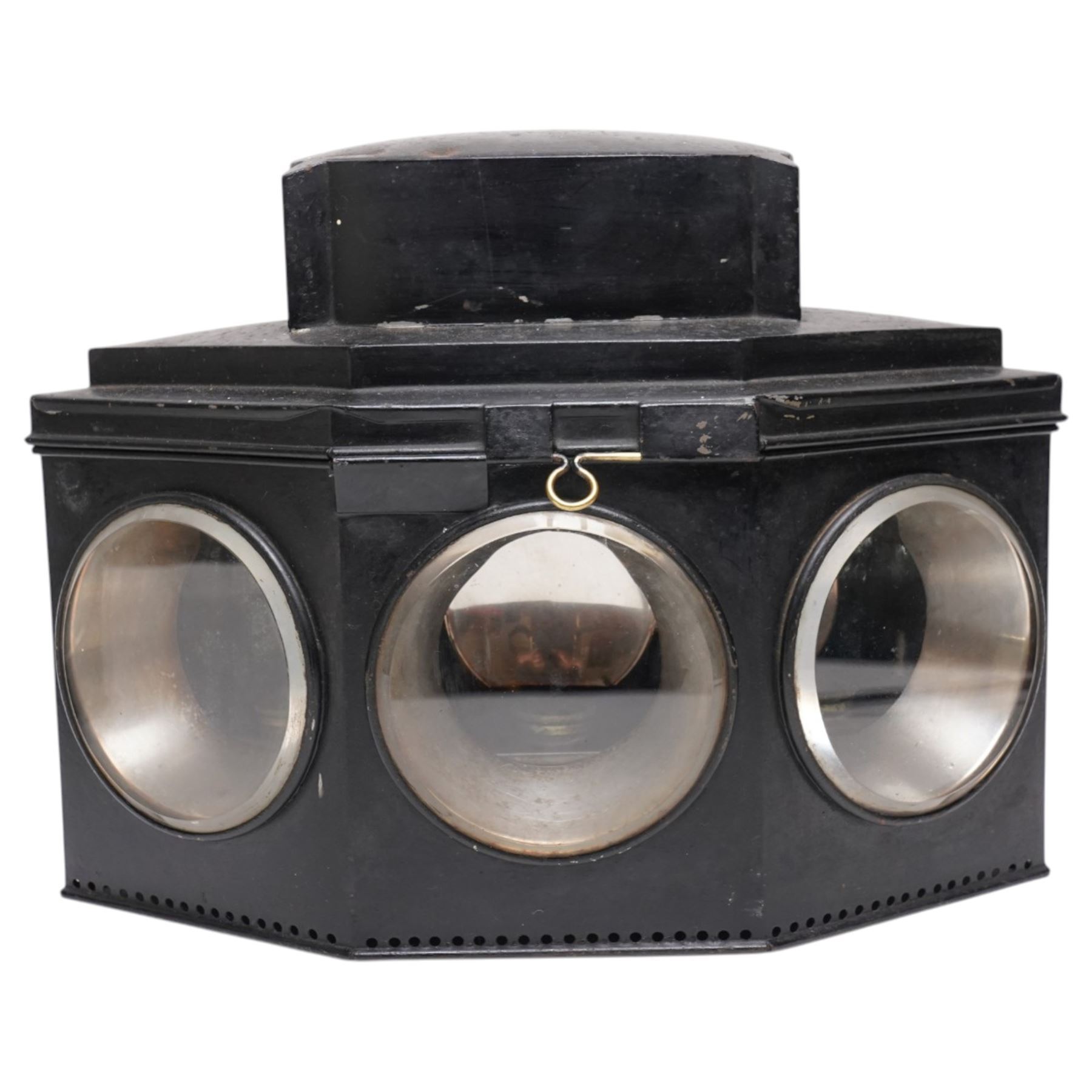 Victorian black toleware triple footboard carriage lamp of hexagonal form, with three circular bevelled lens, mounting clip to rear