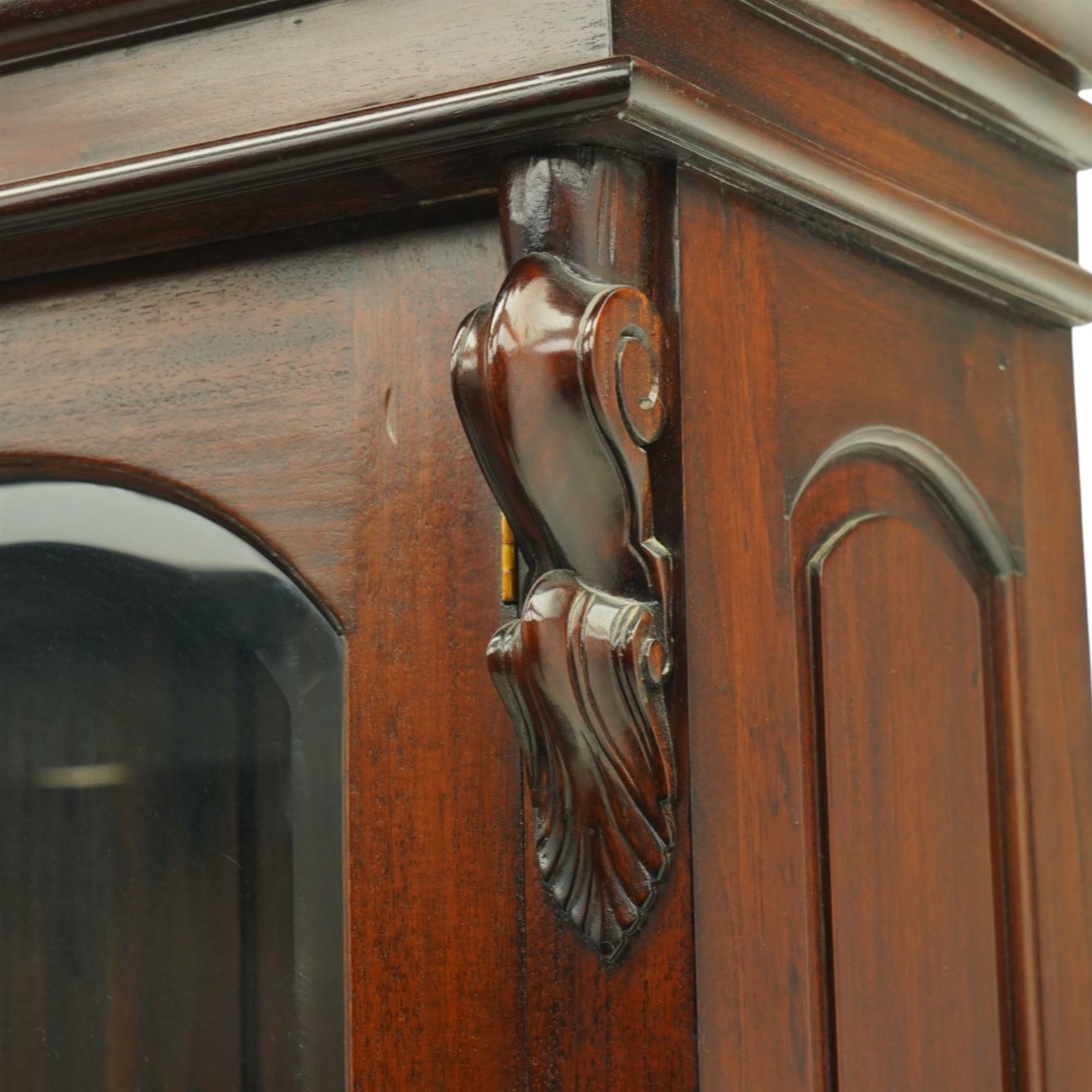 Victorian revival hardwood dresser, projecting moulded cornice above three glazed doors enclosing shelves, moulded top over three drawers and three panelled cupboard doors, flanked by applied carved scroll brackets, on plinth base,