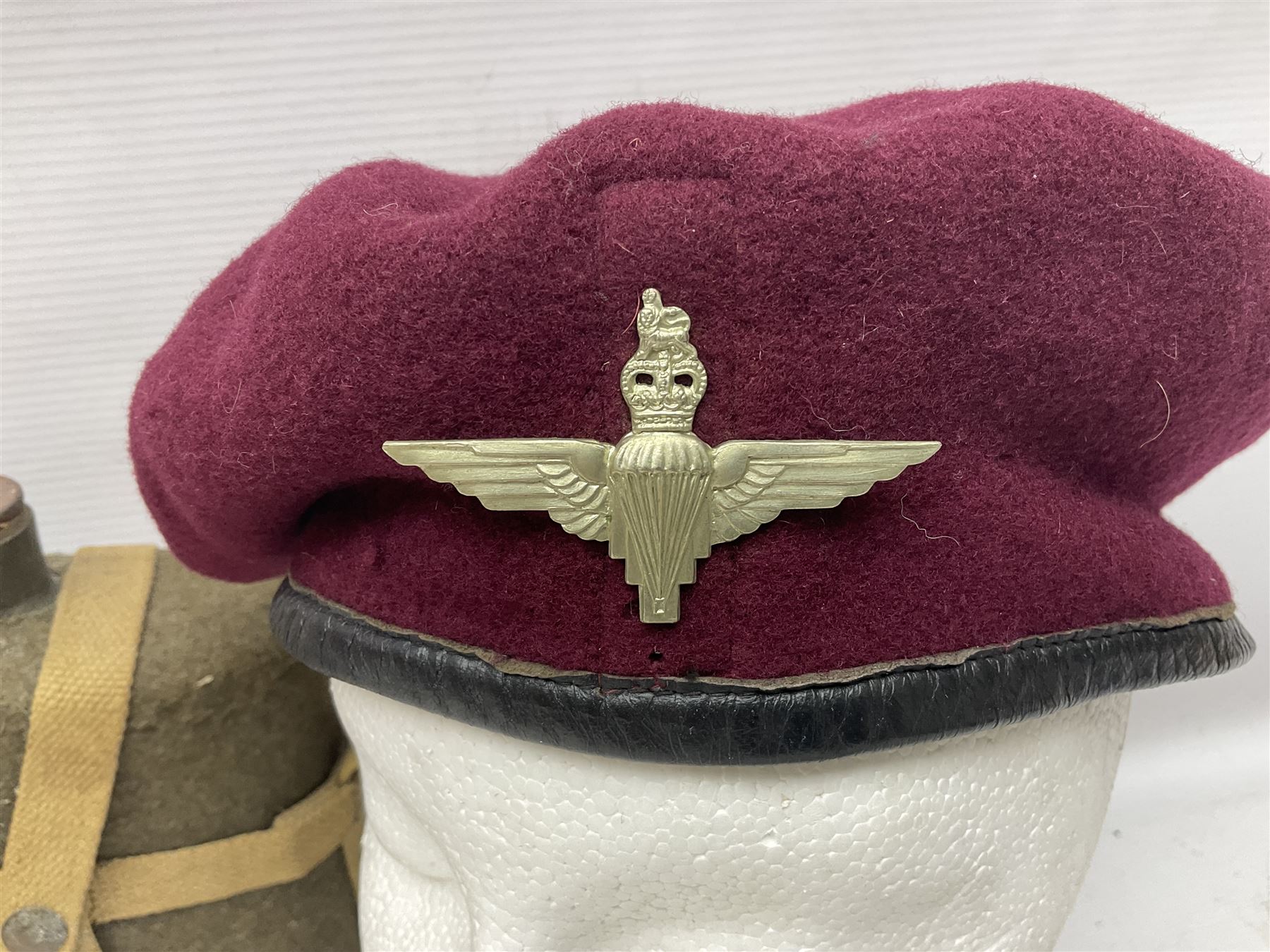 Five military caps/berets comprising two peaked caps with 'Yorkshire' and 'Royal Engineers' badges; maroon beret with parachute regiment badge; red beret with Military Police badge; and AB seaman hat with HM Submarines band; and a felt and webbing covered water bottle (6)