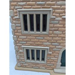 1:24 scale stone effect three-storey cottage dolls house, with green arched door and lattice effect windows, decorated to the interior with wooden floors, wired lighting and fire places, H45cm, W57cm, D26cm