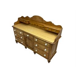 Victorian pine dresser, shaped raised back with small drawers, fitted with seven drawers and central panelled cupboards, on turned feet