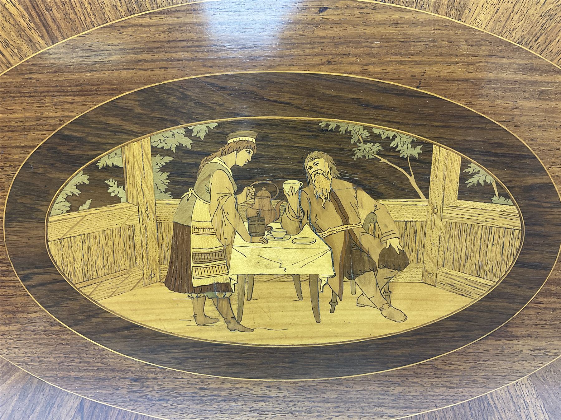 Late 19th/early 20th century mahogany and marquetry inlaid tray, of oval form with twin scrolled handles and moulded border, the central panel inlaid with figures seated at a table drinking tea, L99cm