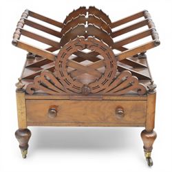 19th century mahogany music canterbury, with pierced dividers united by turned handles, above a single frieze drawer, raised upon baluster supports on brass castors