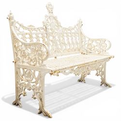 Victorian revival heavy cast iron garden bench, ornate back rest with scrolls, floral motifs and central crest, pierced lattice seat, curved arms and decorative legs, painted in antique white, in the Gothic Coalbrookdale style