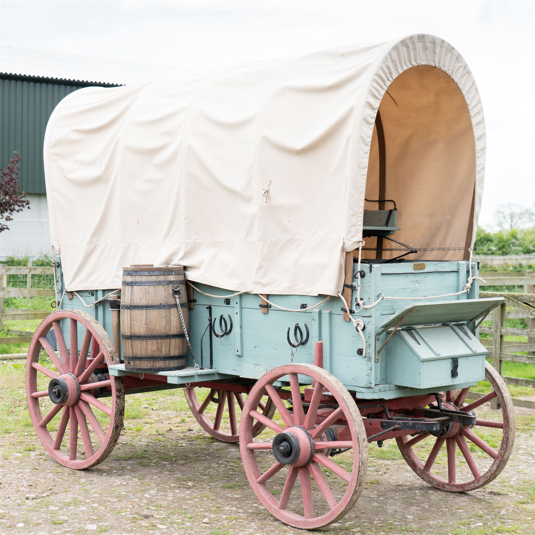 Western Covered Chuck Wagon

A large four wheeled covered wagon of timber construction, painted pale green with red painted wooden spoked wheels and a cream canvas tilt over an arched frame. The wagon has a traditional box body with covered rear compartment, front driving position, underbody turntable steering and iron fittings throughout. Fitted with external equipment details including a side mounted barrel, lidded storage chest, rope tie downs, horseshoe fittings and rear storage box.

Features

• Pale green painted timber body
• Cream canvas tilt over arched frame
• Covered rear compartment
• Front driving position
• Side mounted barrel
• External lidded storage chest
• Rear storage box
• Wooden spoked wheels
• Iron tyres
• Underbody turntable steering
• Rope tie downs
• Horseshoe fittings
• Iron hardware and brackets
• Brass restoration plaque to rear

Dimensions:
Overall length: 335 cm
Width: 170 cm
Height: 275 cm

Wheel Diameters:
Front wheels: 92 cm
Rear wheels: 112 cm

Seating:
Driver: 1
Passenger: Rear covered compartment
