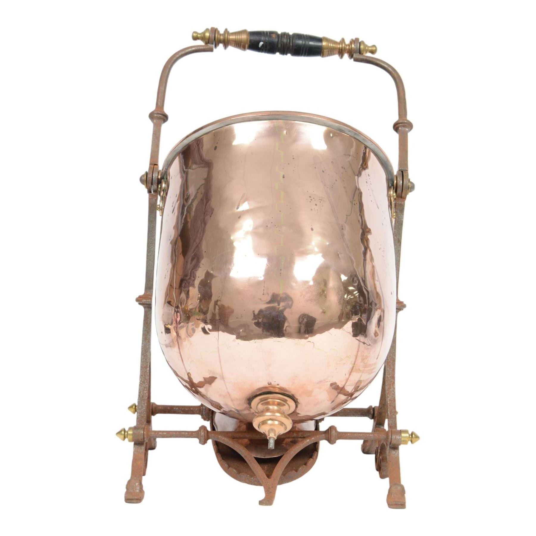 Victorian copper coal scuttle, the helmet shaped body tilting upon stand, with embossed hinged cover, turned wood handle and scoop H53cm

