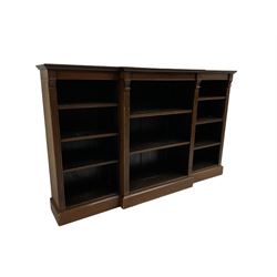 Edwardian mahogany breakfront bookcase, fitted with eight adjustable shelves, flanked by reeded uprights with corinthian capitals 