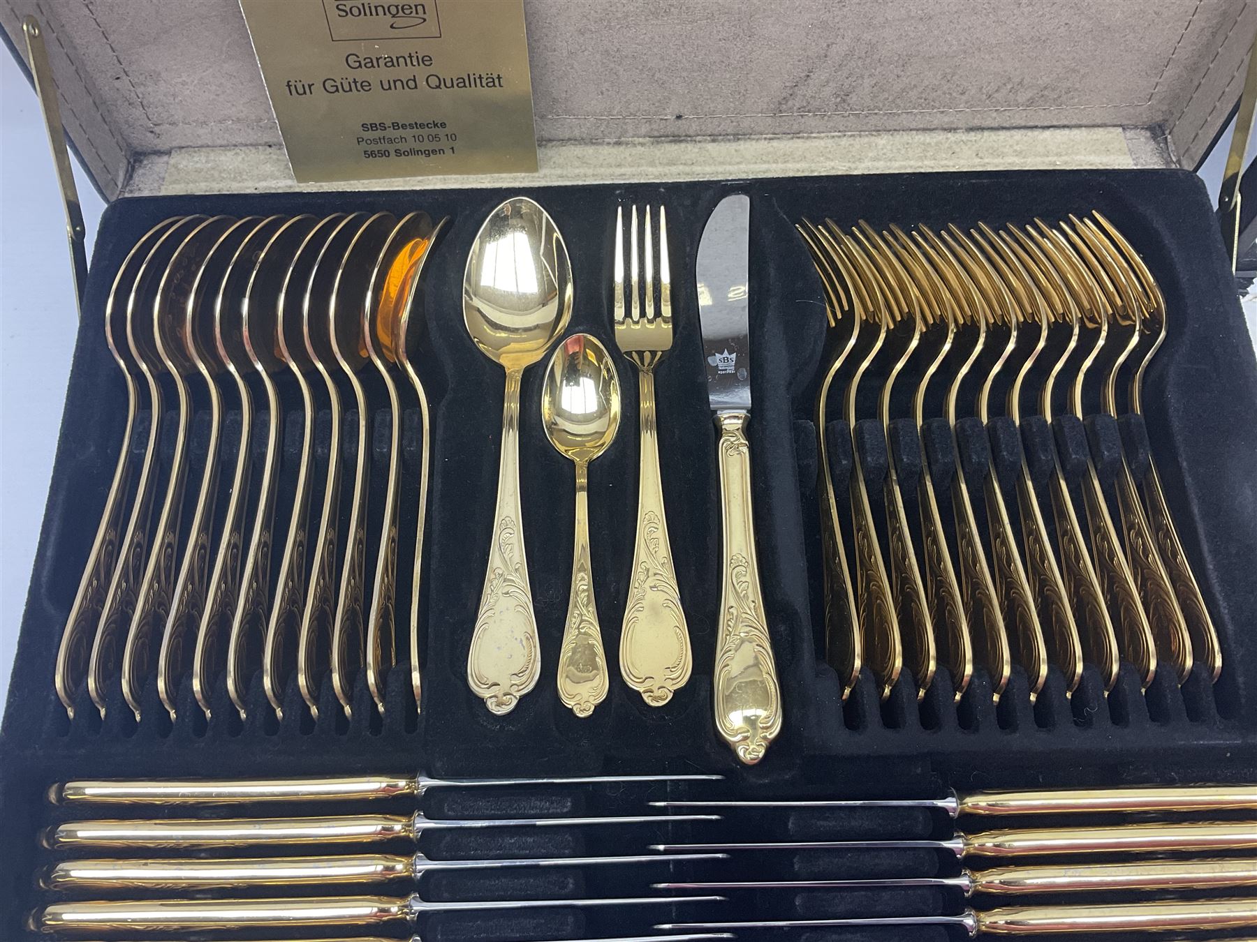 Bestecke Solingen canteen of gold plated cutlery for twelve place settings, including ladle, cake slice and serving spoons, contained within a briefcase, together with a matching set twelve of Bestecke Solingen gold plated fish knives and forks, in fitted case 