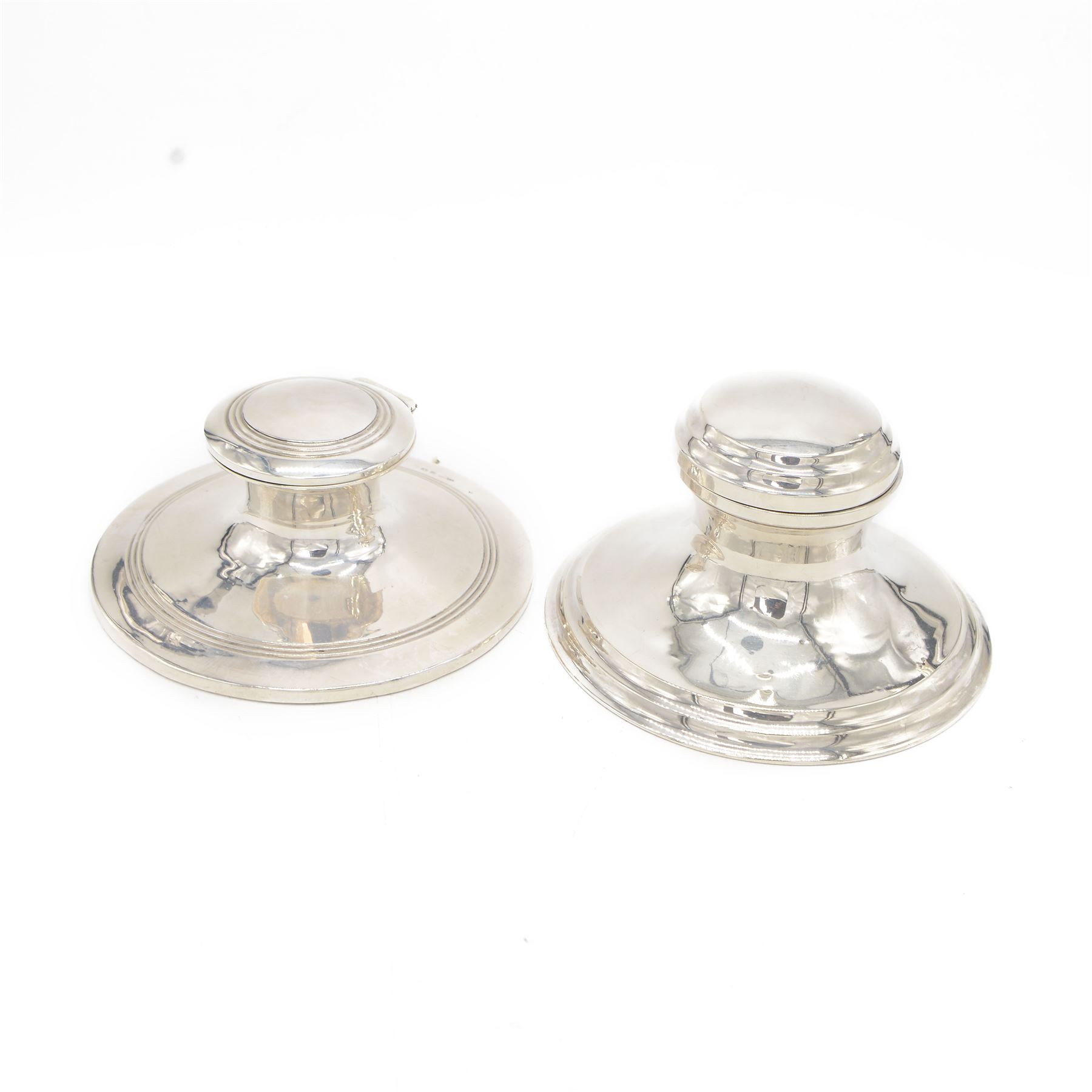 Two early 20th century silver mounted capstan inkwells, both of typical form, the first example hallmarked Wilmot Manufacturing Co, Birmingham 1918, the second example hallmarked Spooner Clowes & Co, Birmingham 1908, largest D15cm, H9.5cm