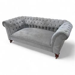 Early 20th century Chesterfield drop-arm two-seat settee, traditional shape with rolled arms and back, upholstered in buttoned pale blue fabric, on ogee block feet with brass castors 