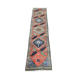 Red ground runner rug, four fielded medallions surrounded by floral and animal decoration, repeating boarder 