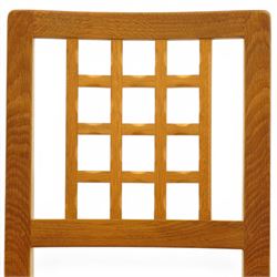 Knightman - eight oak dining chairs, the rectangular back with square section lattice splat enclosed by straight stiles and top rail, drop in upholstered seat in pale patterned fabric, raised on square section legs with chamfered detailing united by stretchers, with carved knight signature, by Horace Knight of Thirsk