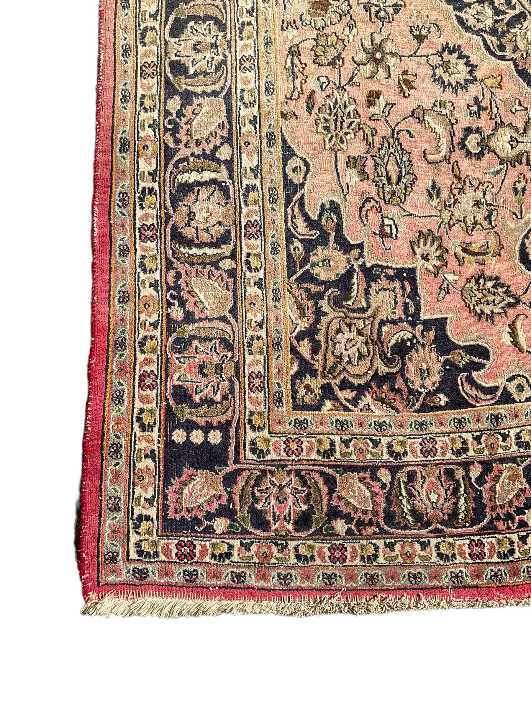 Persian Kashan carpet, blue shaped medallions and spandrels, the field decorated with interlacing branch and stylised plant motifs, repeating floral design borders