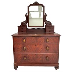 Victorian scumbled pine dressing chest, raised swing mirror in moulded frame with scrolled carved pediment, foliage S-scroll carved supports over trinket drawers, moulded rectangular top with rounded corners over two short and two long drawers, skirted base on turned feet, scumbled to resemble mahogany 