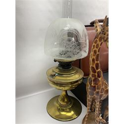 Brass oil lamp, with etched floral glass shade, leather Gladstone style doctors bag, leather satchel and vintage vanity case, three graduating wooden giraffes and other wood and metal ware, lamp H54cm