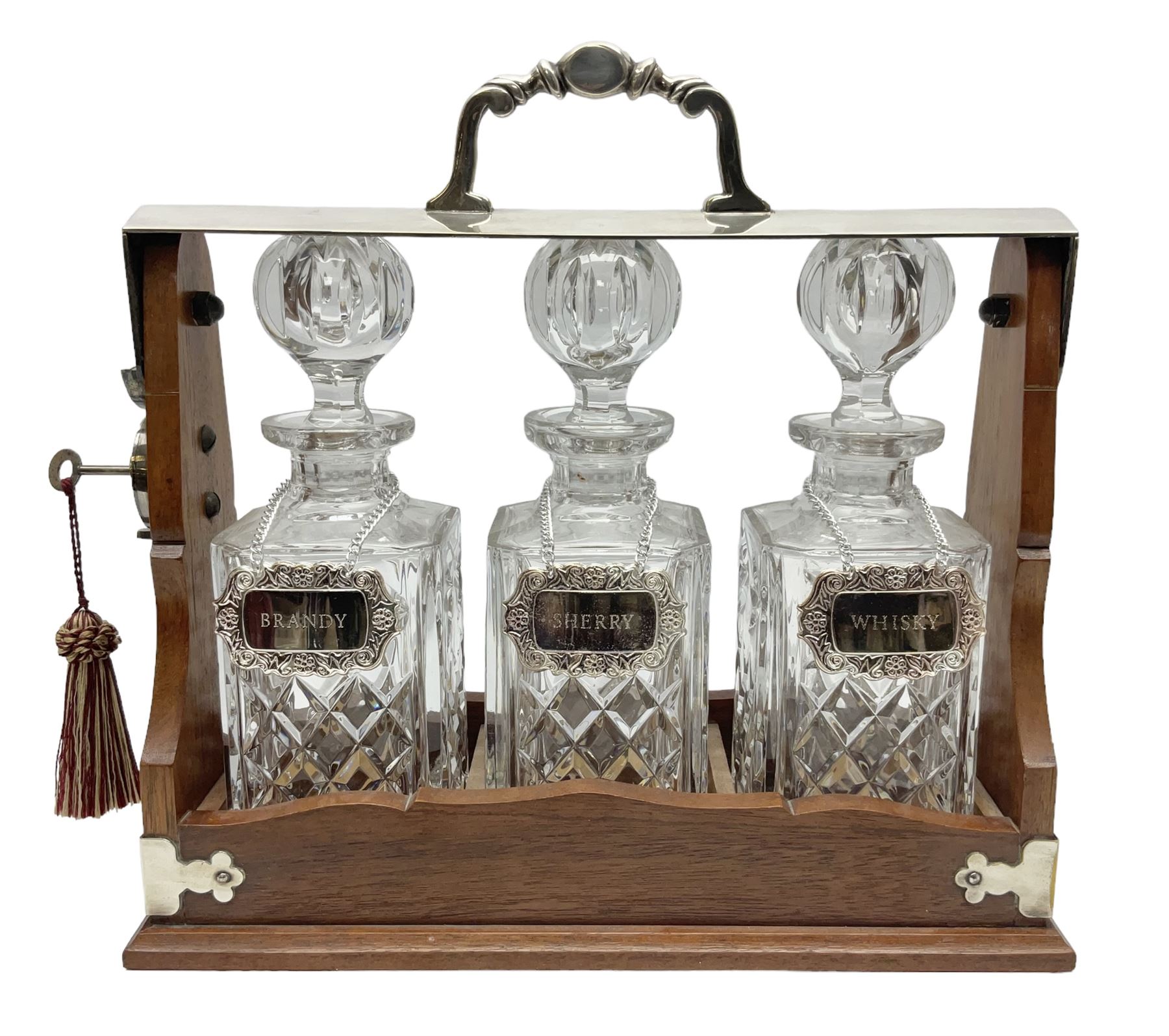 Edwardian silver plate mounted oak tantalus, containing three square sided cut glass decanters, complete with key, H33cm