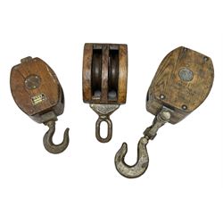 Three ship pulleys comprising wooden block double with stiff swivel hook, wooden block double with swivel eye and wooden block with stiff swivel hook, largest example L52cm