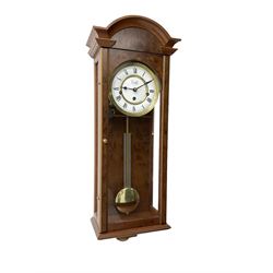 Comitti,  London - 20th century 8-day chiming wall clock in a walnut case, with a moulded break-arch top and full length glazed door and side panels, two part enamel dial with spade hands and visible gridiron pendulum, three train spring driven movement chiming the quarters on 5 gong rods.