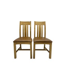 Pair of oak dining chairs, tan faux leather seat