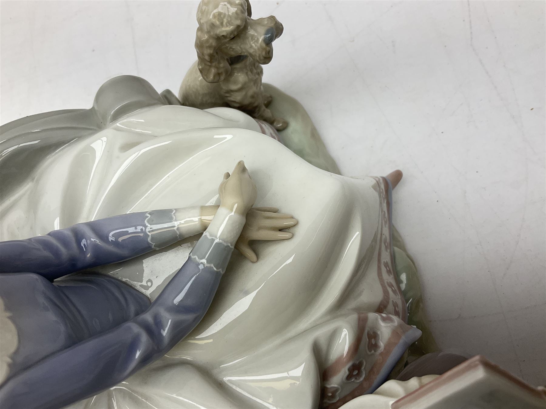 Lladro figure, Poetry of Love, modelled as a boy seated reading from a book next to a girl on garden bench with a dog at her feet, sculpted by Regino Torrijos, with original box, no 5442, year issued 1987, year retired 1998, H22cm