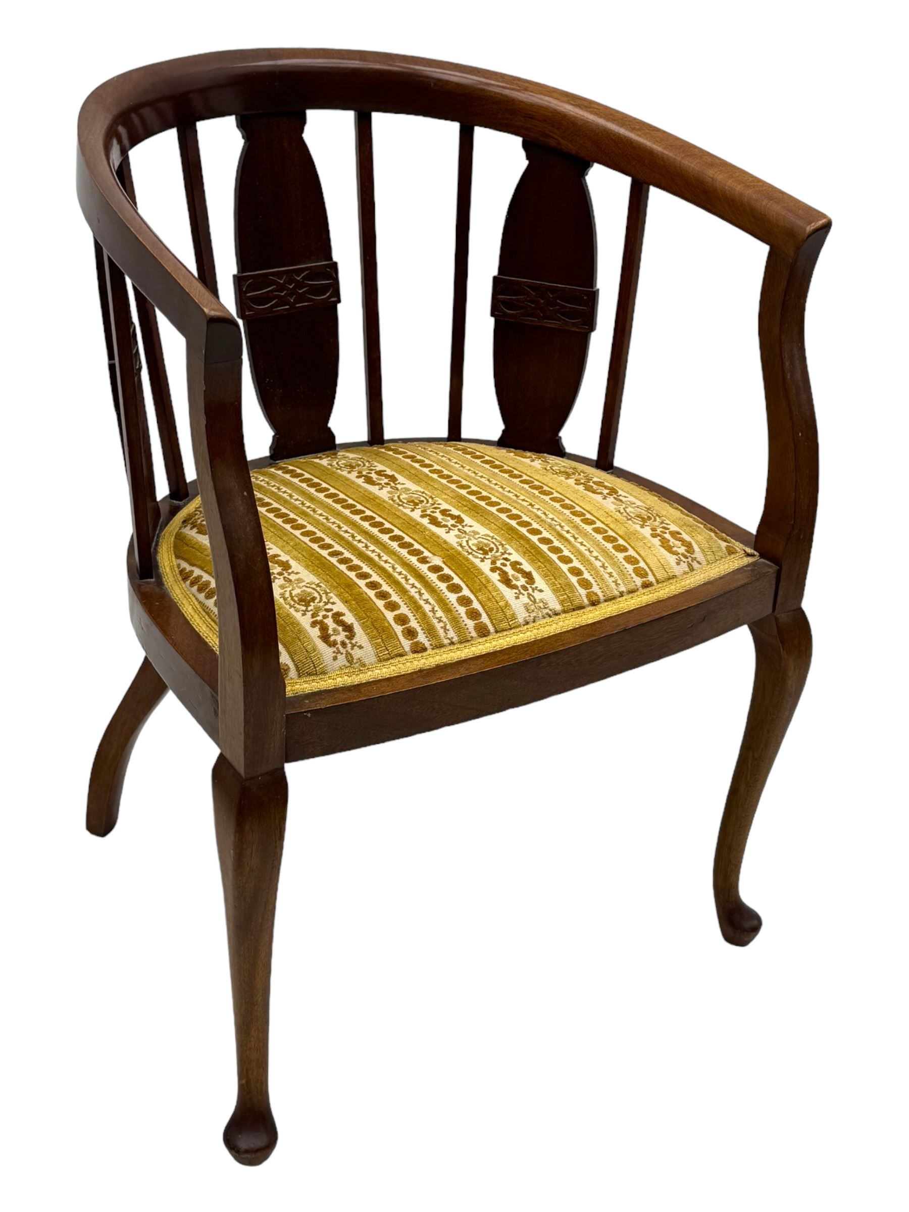 Late Victorian mahogany framed tub chair, rounded backrest with vertical splats and three carved oval medallions, upholstered seat in yellow patterned fabric, on cabriole supports