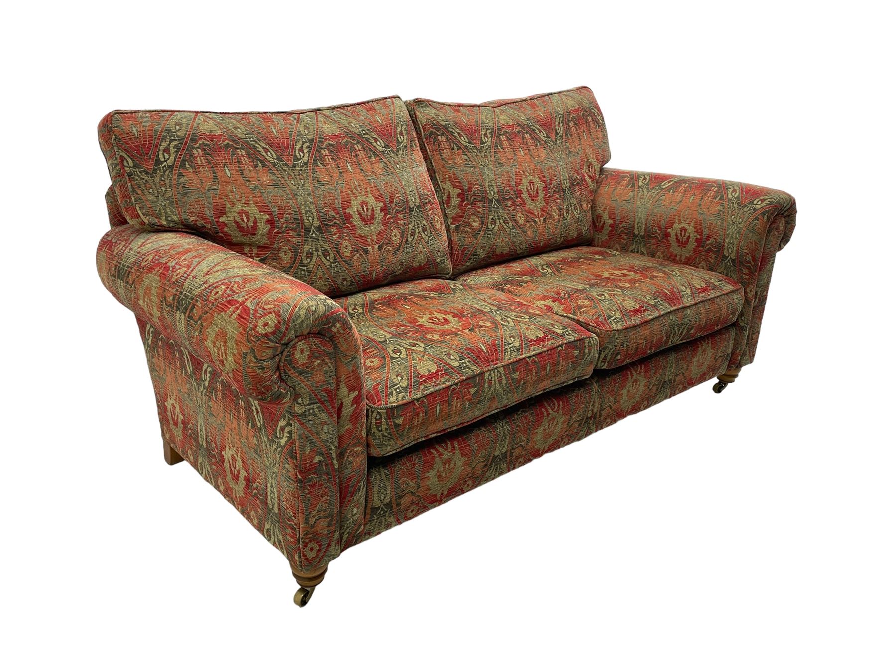 Duresta - 'Beaminster' grande two-seat sofa, traditional shape with rolled arms, upholstered in 'Althorp' russet and stone floral pattern fabric, on turned feet with brass castors
