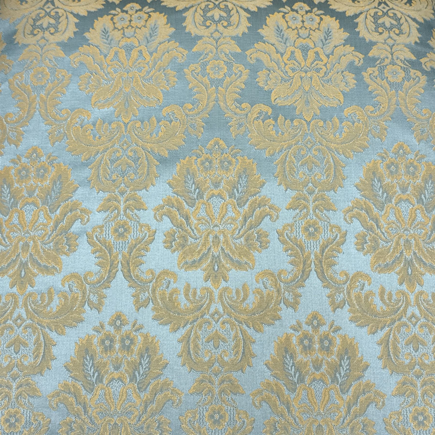 Georgian design carved walnut framed wingback armchair, upholstered in pale blue and gilt floral damask, with shaped loose seat cushion and rolled arms, raised on scallop and cartouche carved front cabriole supports terminating to pad feet