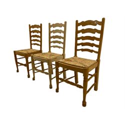 Three beech ladder back chairs with rush seats