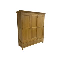 Light ash triple wardrobe, enclosed by three panelled doors, the base fitted with two drawers