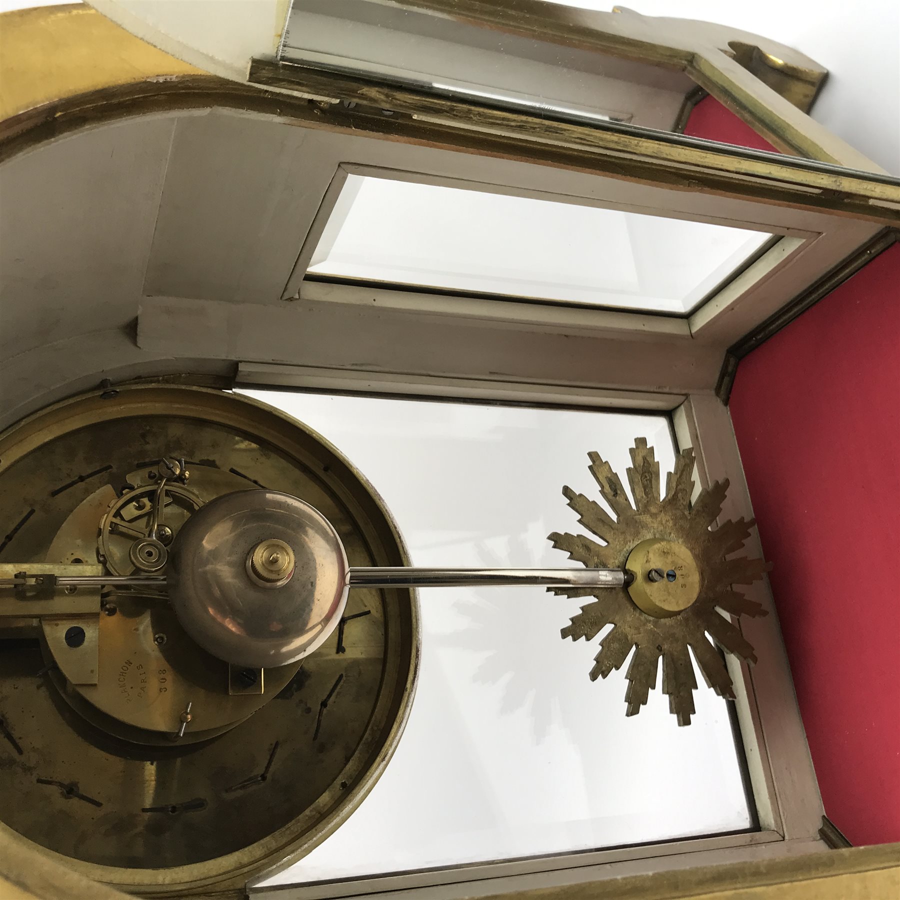 20th century French clock by Planchon Paris, decorative gilt case with shell pediment set on scrolled leafage, circular porcelain segmented dial with Roman and Arabic numerals, bevel glazed front and sides with mirrored interior, acanthus carved feet with scrolled terminals, shell to apron to match, eight day movement striking the hours and half on bell, sunburst and mask cast pendulum, with key, W36cm, H59cm, D21cm