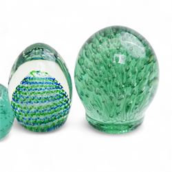 Eleven Victorian and later green glass dump paperweights, with floral and bubble inclusions, largest H14cm 