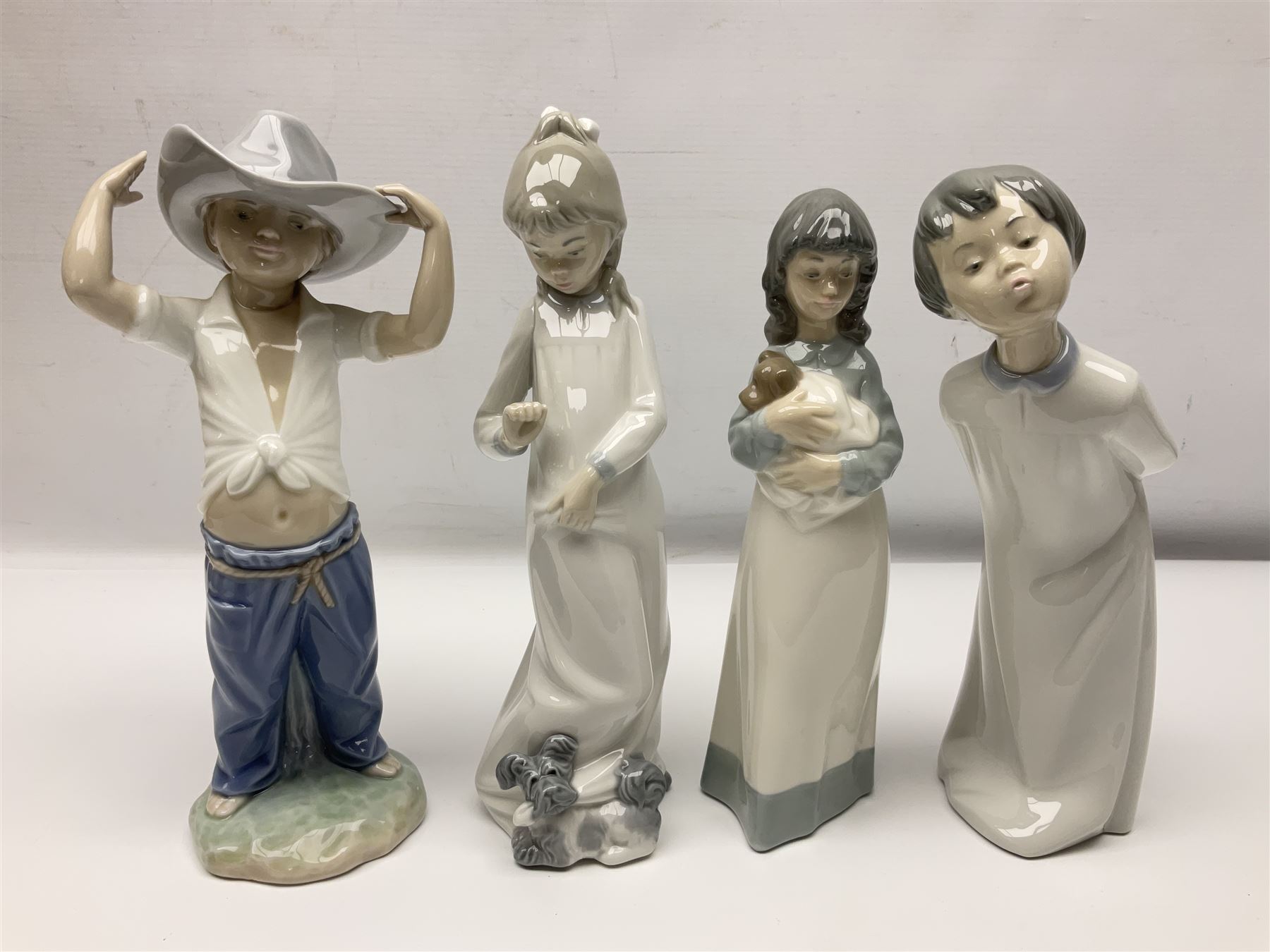 Eleven Nao figures to include Cowboy, Girl with Puppy, Clown, Girl in hat etc 